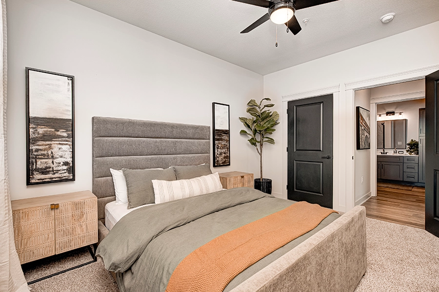 There are several reasons to choose a coach house apartment like the ones offered at Crossing 5 Apartments. Modern apartment bedroom looking into a large bathroom