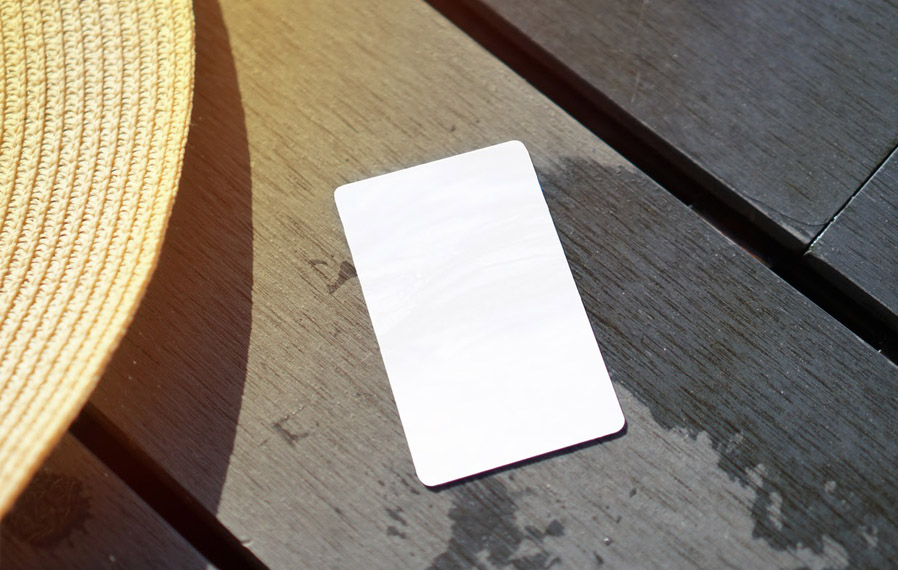Don't forget your pool pass to to take a refreshing swim at Midtown Flats. Summer hat and key card on a deck floor.